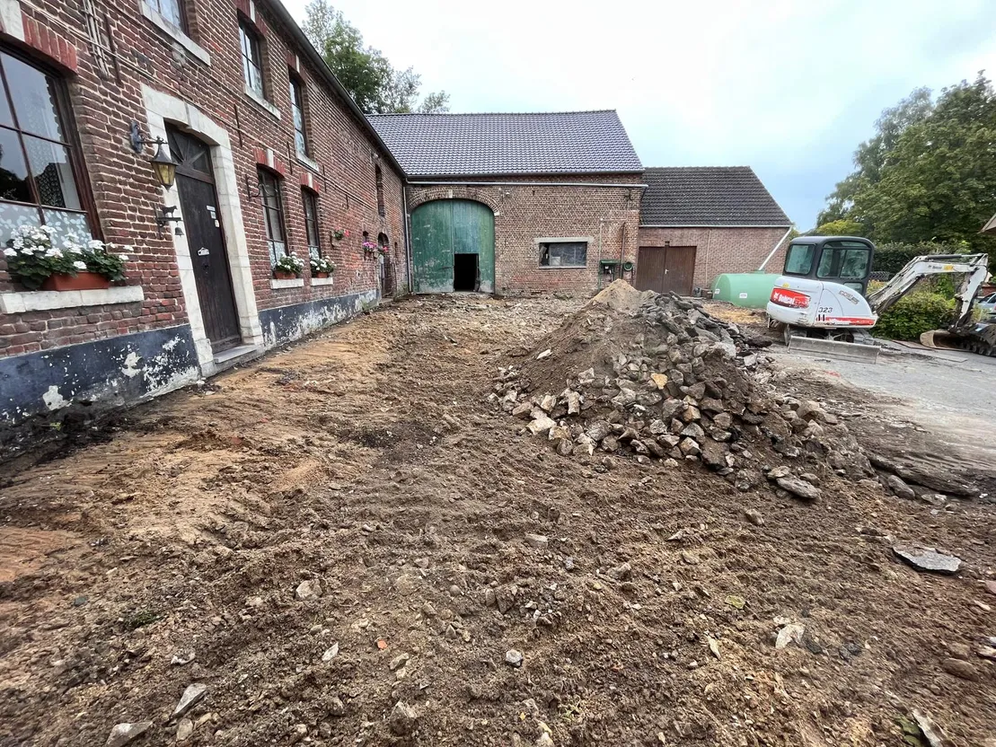 Cour de ferme décaissée, mini-pelle au travail