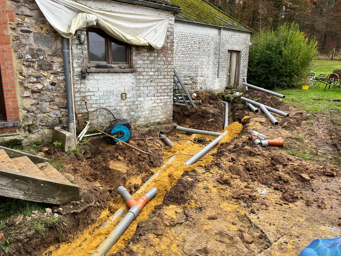 Réseau en PVC sur lit de sable au pied d'une ferme
